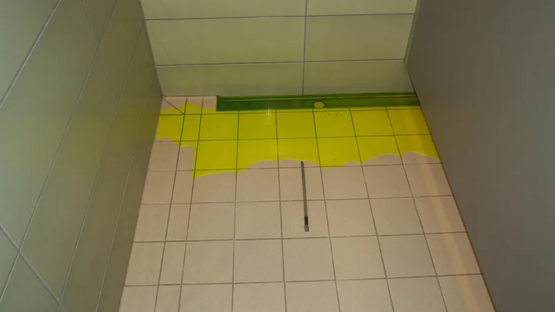 Prüfung mit gelbgrünem Färbemittel im gefliesten Duschbereich