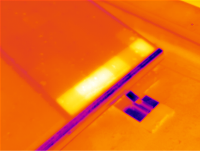 Thermografische Detailaufnahme von PV-Modulen mit einem hell hervortretenden Bereich